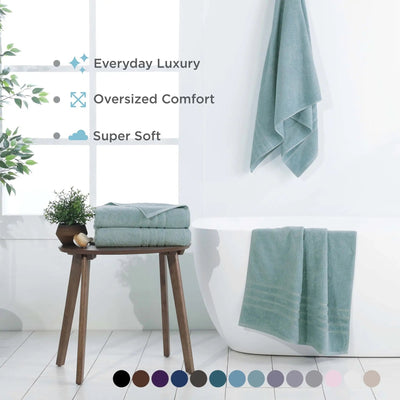 A set of soft, mineral colored bath sheets, set in a bright, modern bathroom. Text overlays highlight key features like 'Everyday Luxury', 'Oversized Comfort', and 'Super Soft', with a color swatch circle graphic at the bottom.