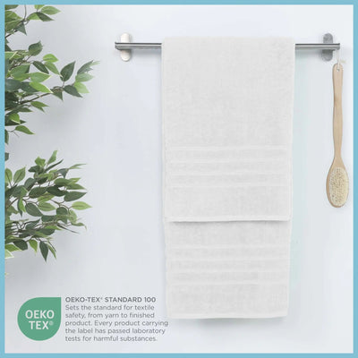 White bath sheet hanging on a rack with a plant and brush, featuring OEKO-TEX certification.