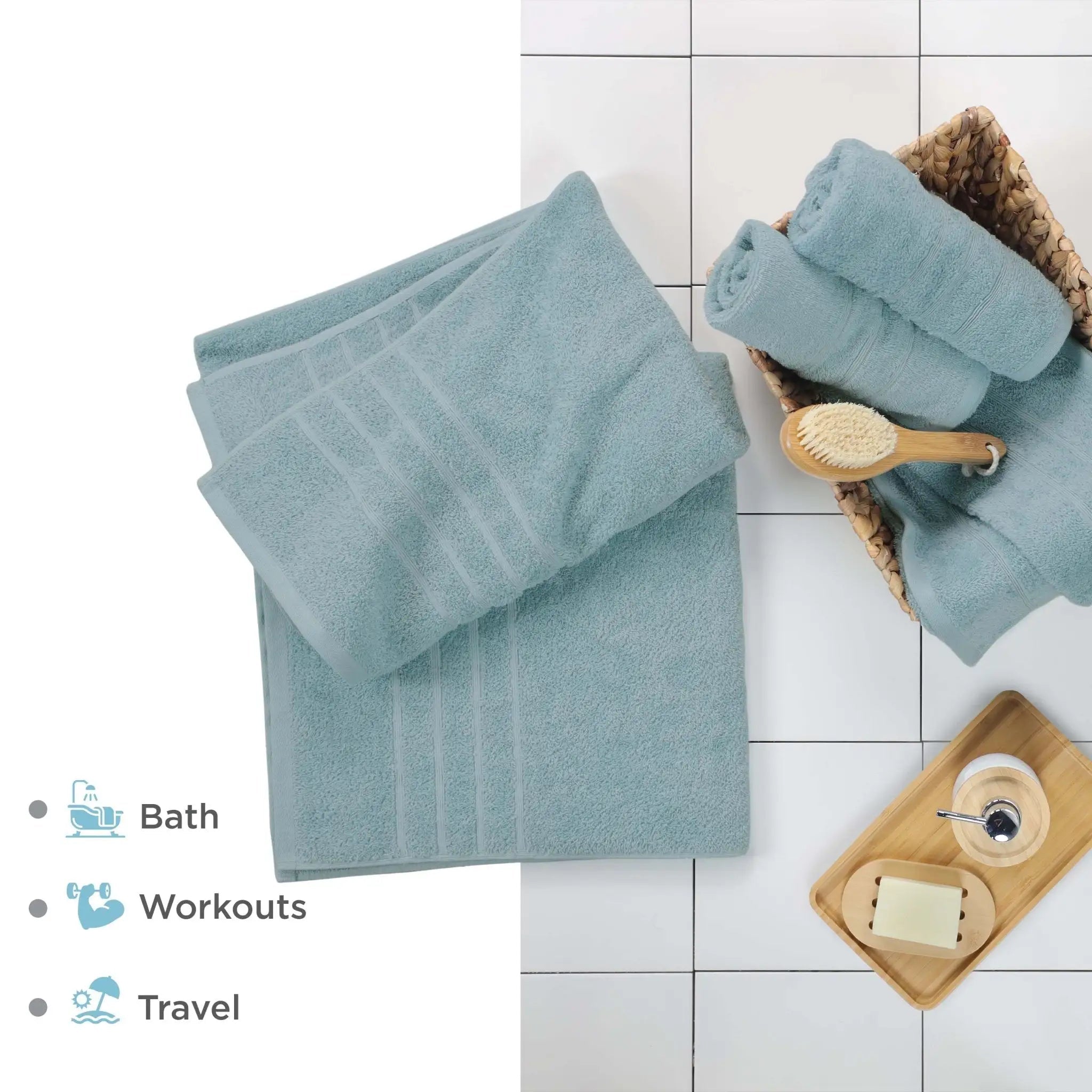 Set of mineral colored bath sheets on a tiled floor with a brush and soap dish.