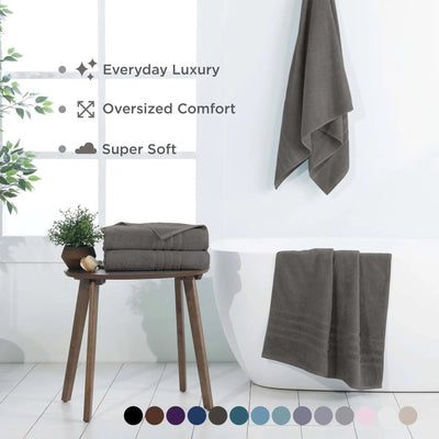 A set of dark gray bath sheets shown in a bright bathroom setting with feature text and a color swatch circle row at the bottom.