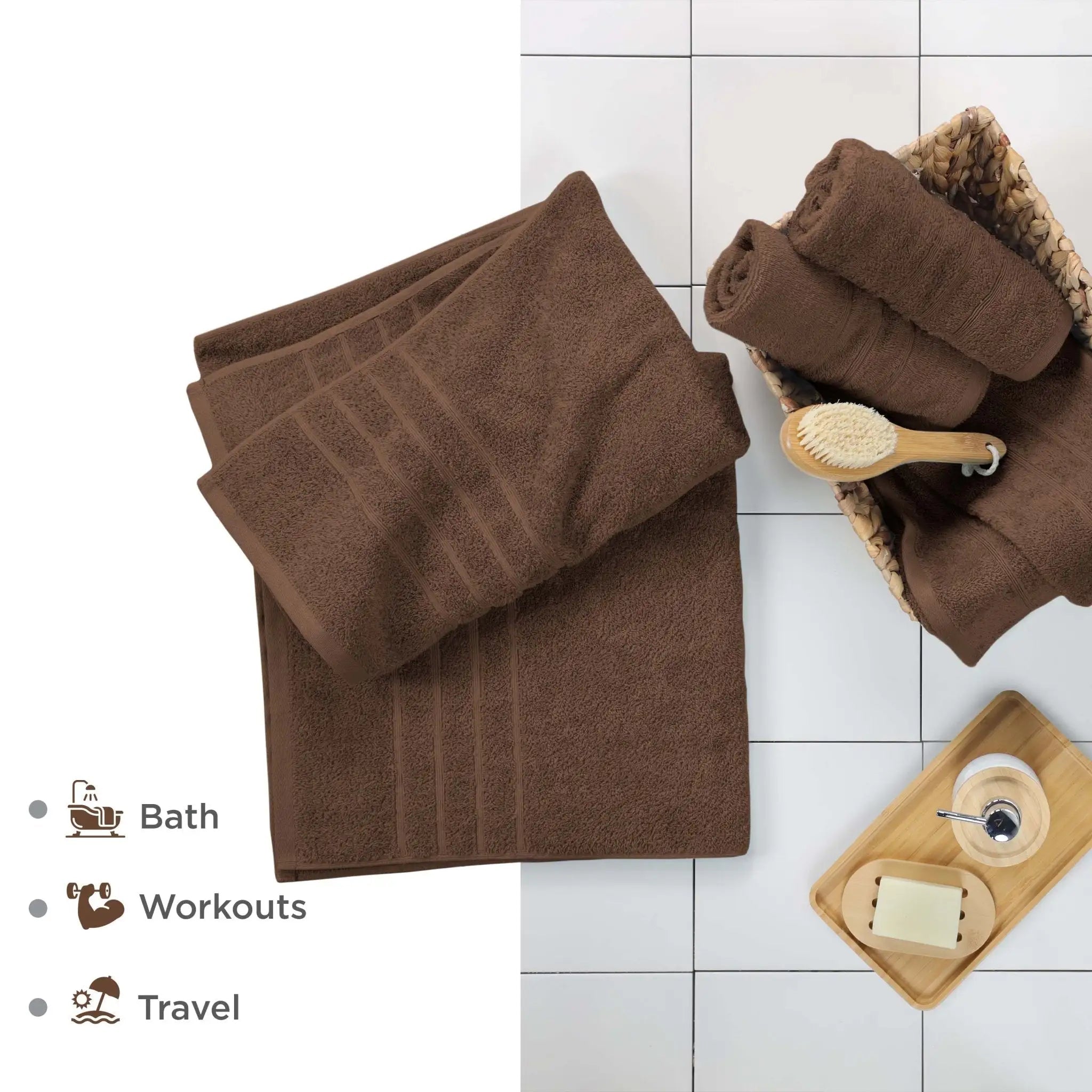Chocolate colored bath sheets on a white tiled floor with accessories.