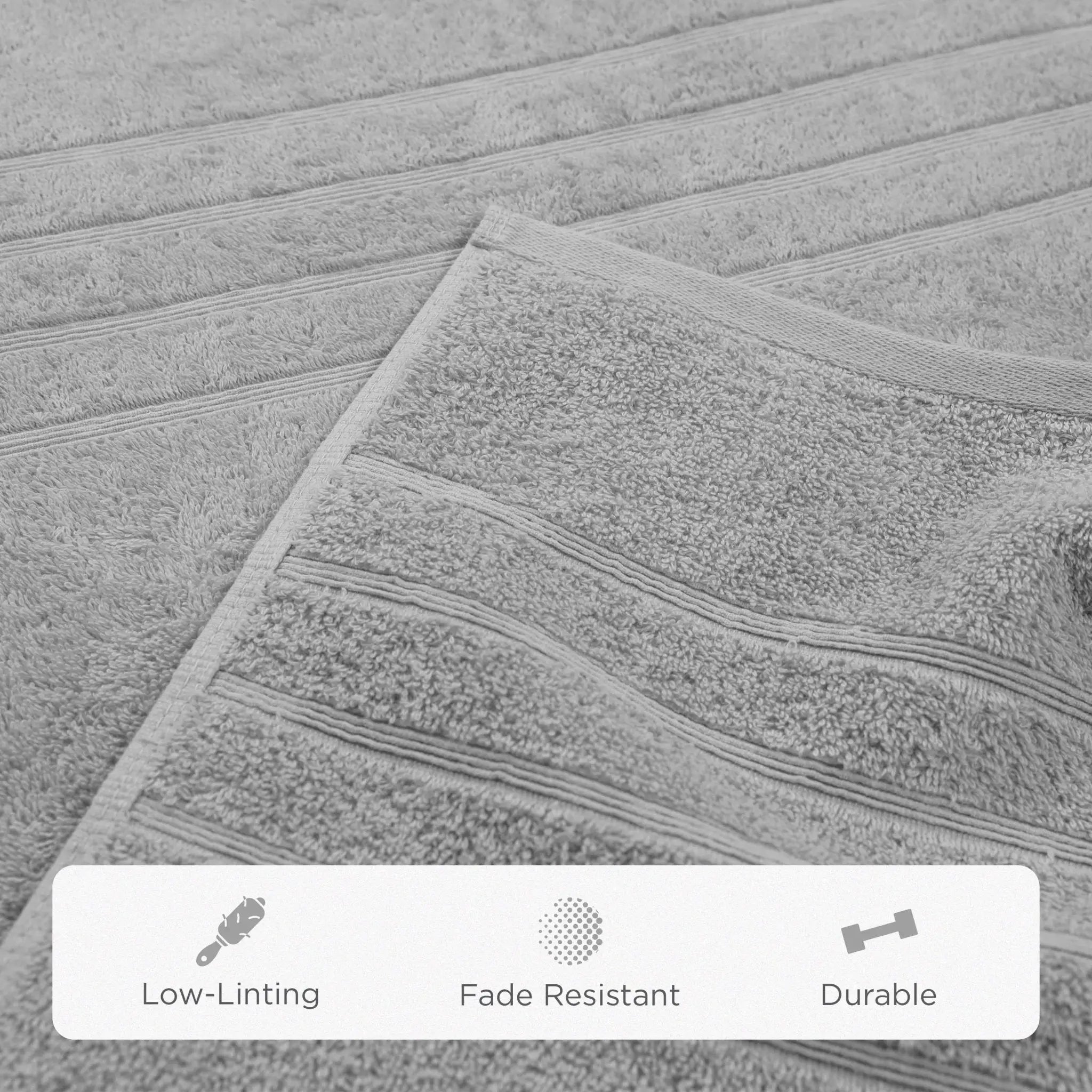 A close-up of a gray textured bath sheet with horizontal ribbed stripes, showing its soft terry texture. A white banner at the bottom features icons and the words 'Low-Linting', 'Fade Resistant', and 'Durable'.