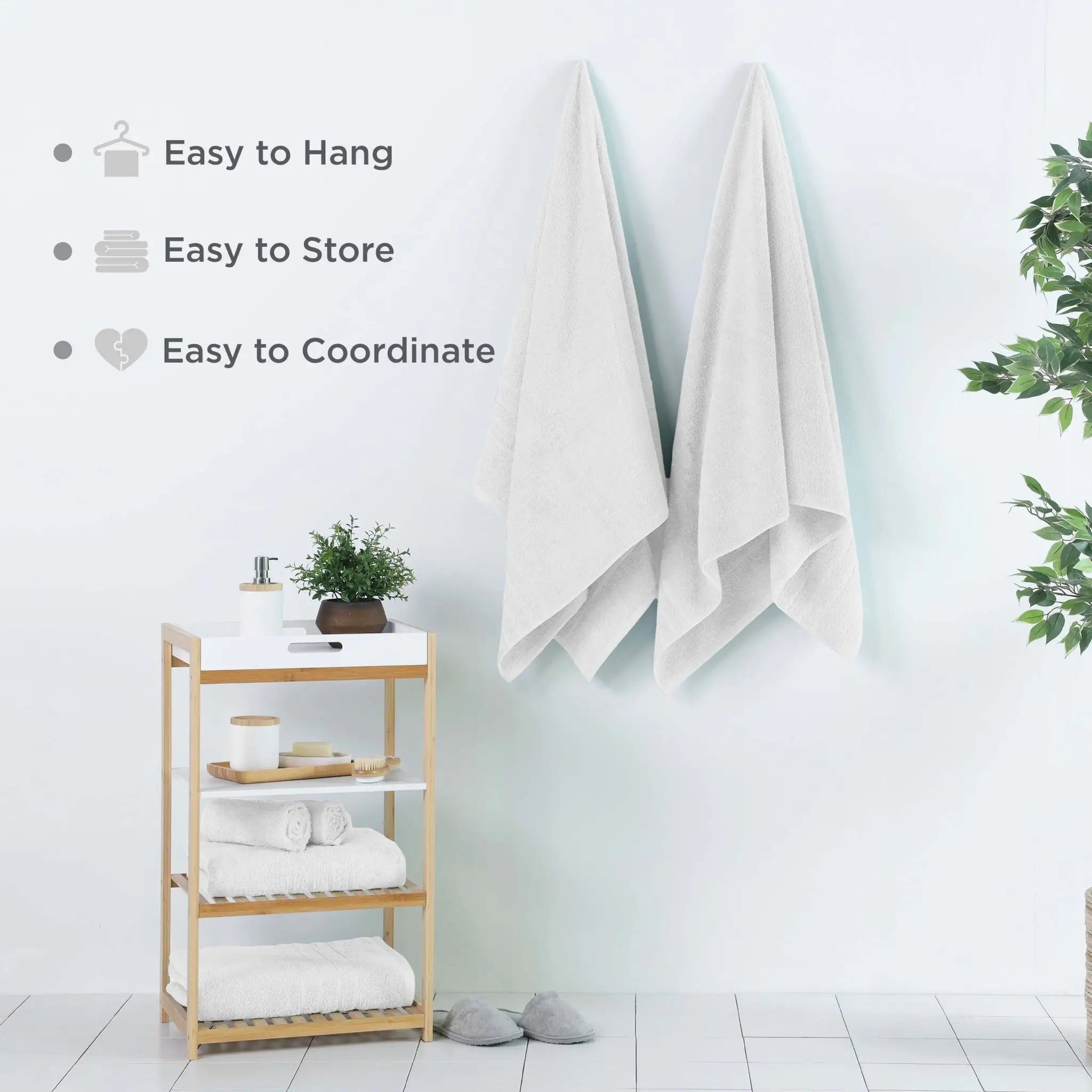 White bath sheets hanging on a rack with a wooden shelf below, against a light blue wall.