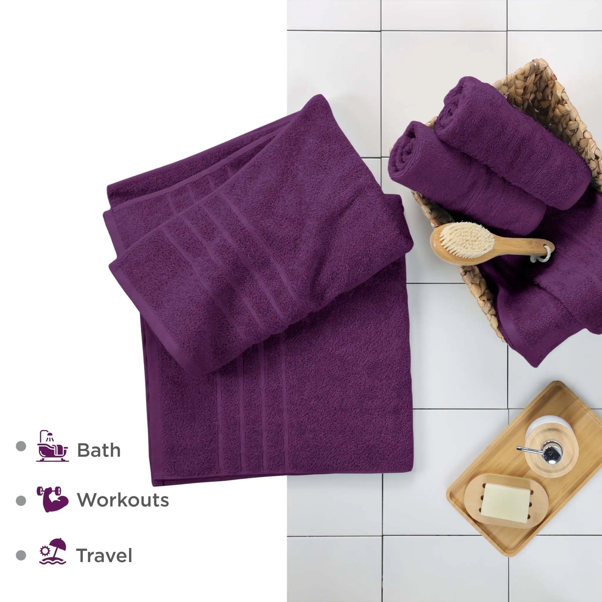 Purple bath sheets on a white tiled floor with accessories.