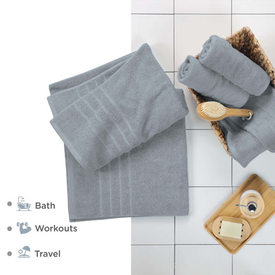 Spa blue bath sheets on a tiled floor with bath accessories.