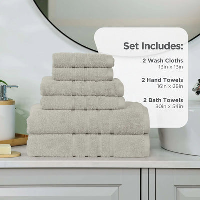 Set of sand-colored towels including wash cloths, hand towels, and bath towels on a bathroom counter.