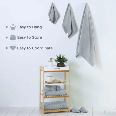 Towel rack with spa blue towel set and a plant on a white wall.