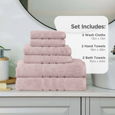 A set of pink towels stacked on a bathroom counter, with a white informational card listing the included sizes and counts: 2 wash cloths, 2 hand towels, and 2 bath towels.
