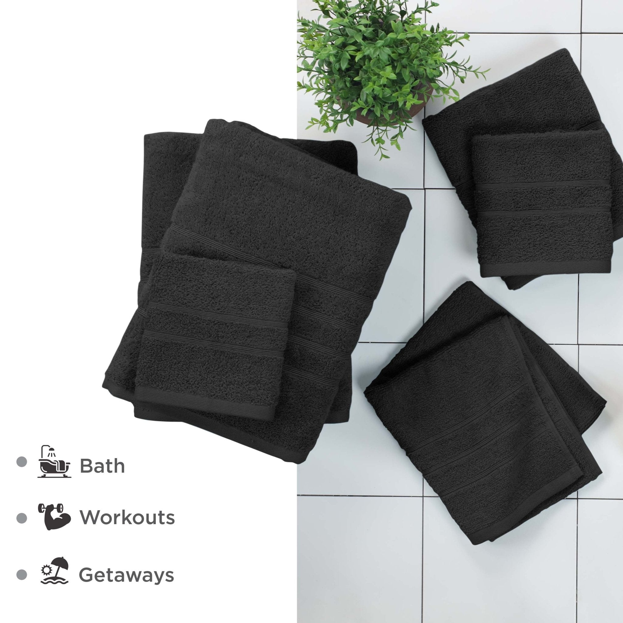 Set of black towels on a white tiled floor with a plant in the background.