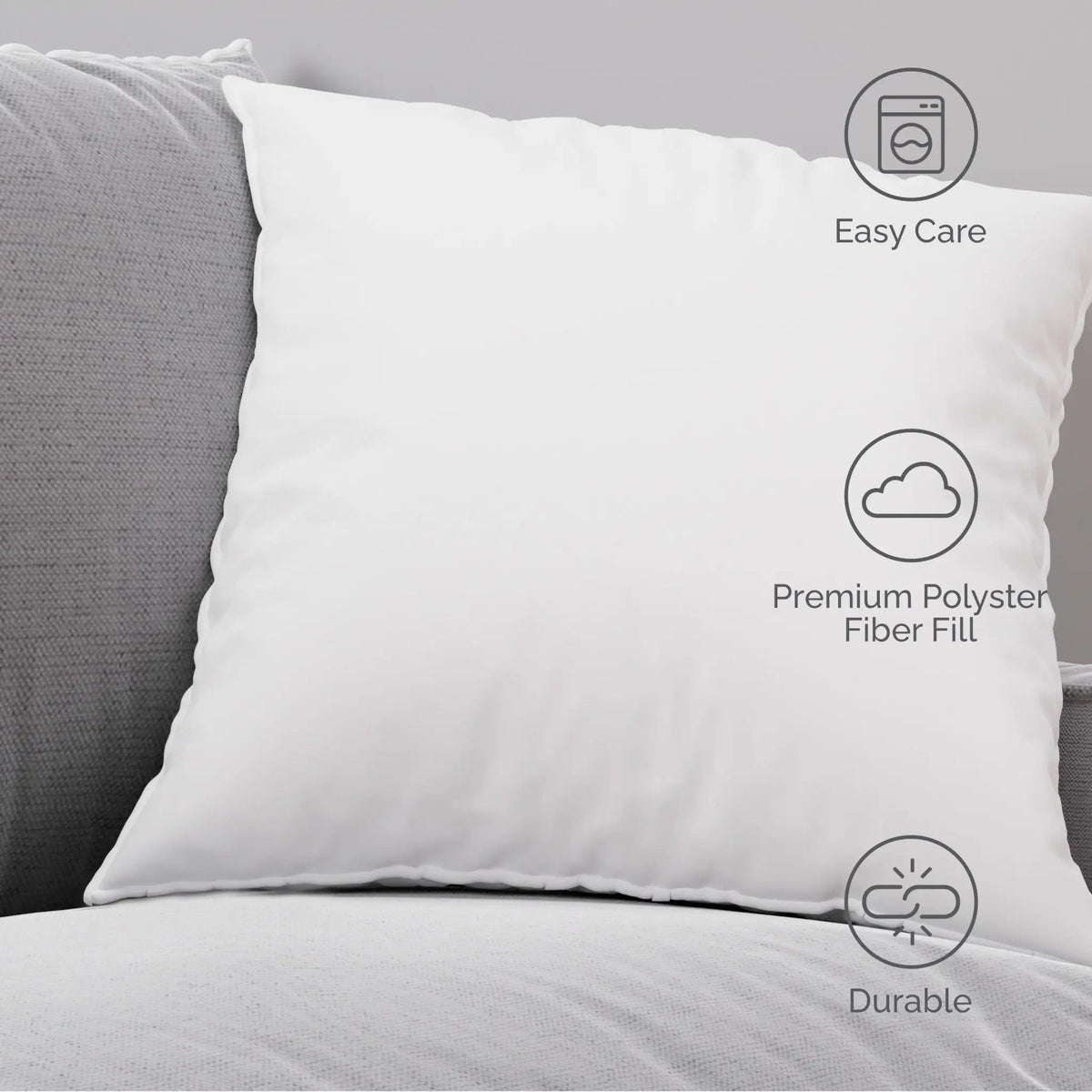 White pillow on a gray couch with care instructions displayed.