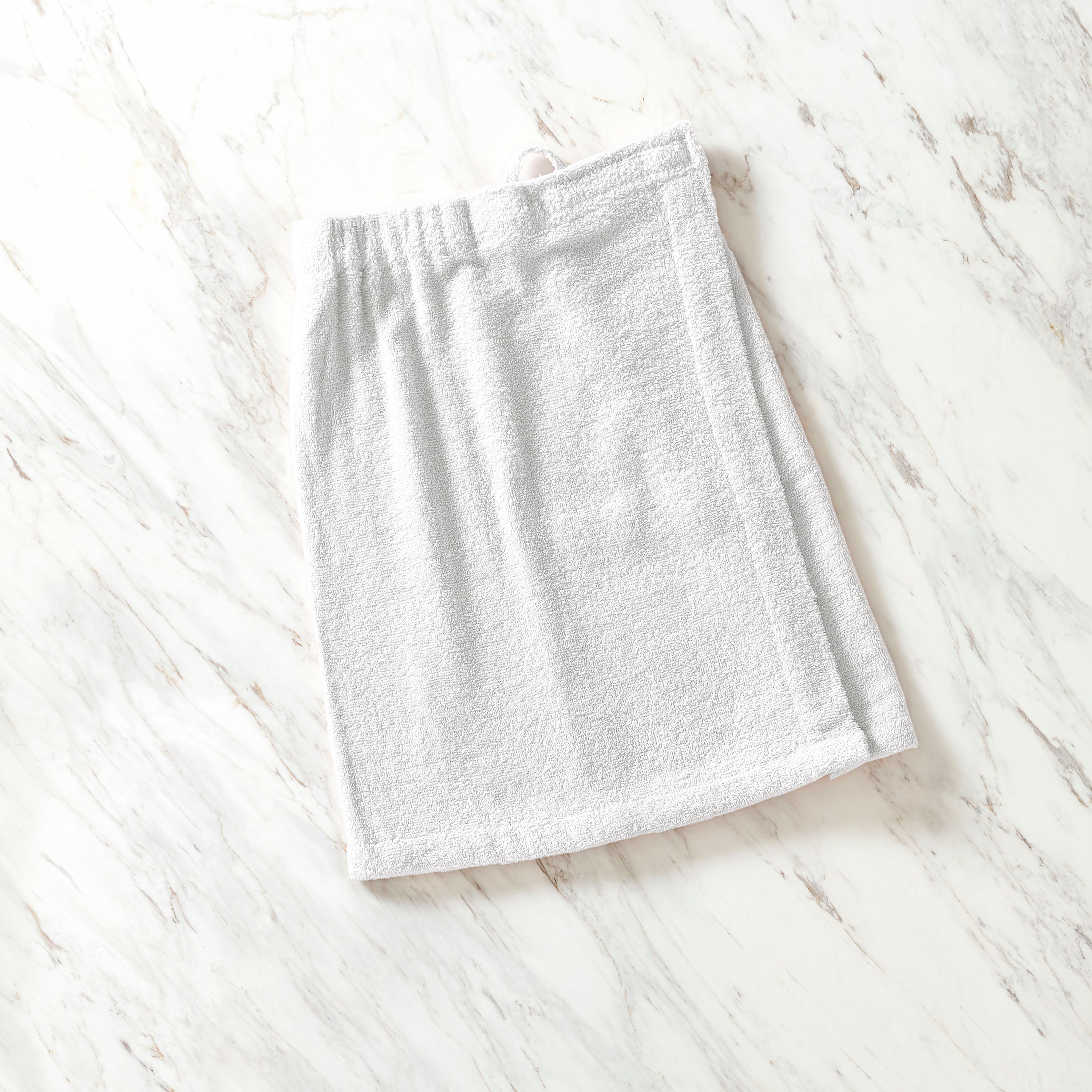 Light gray youth shower wrap with an elastic waistband, laid flat on a marble surface.