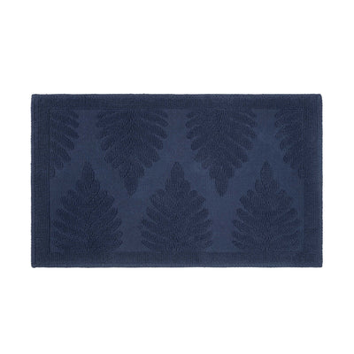 Navy bath rug featuring a textured fern leaf pattern on a solid background.