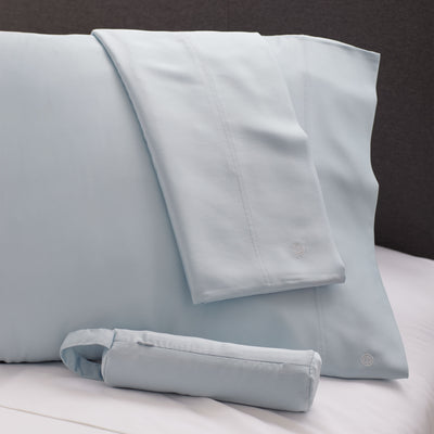 Light blue satin pillowcases with a smooth finish and subtle stitching detail.