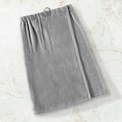 Gray adult shower wrap with an elastic waistband and a loop for hanging, placed on a light marble surface.