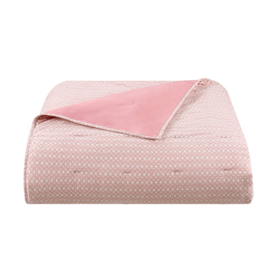 Pink quilt with a subtle pattern on a white background