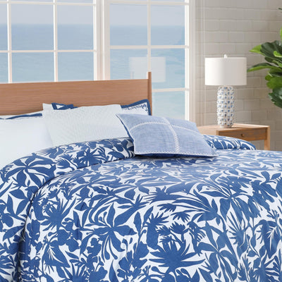 Blue and white floral comforter set on a bed.