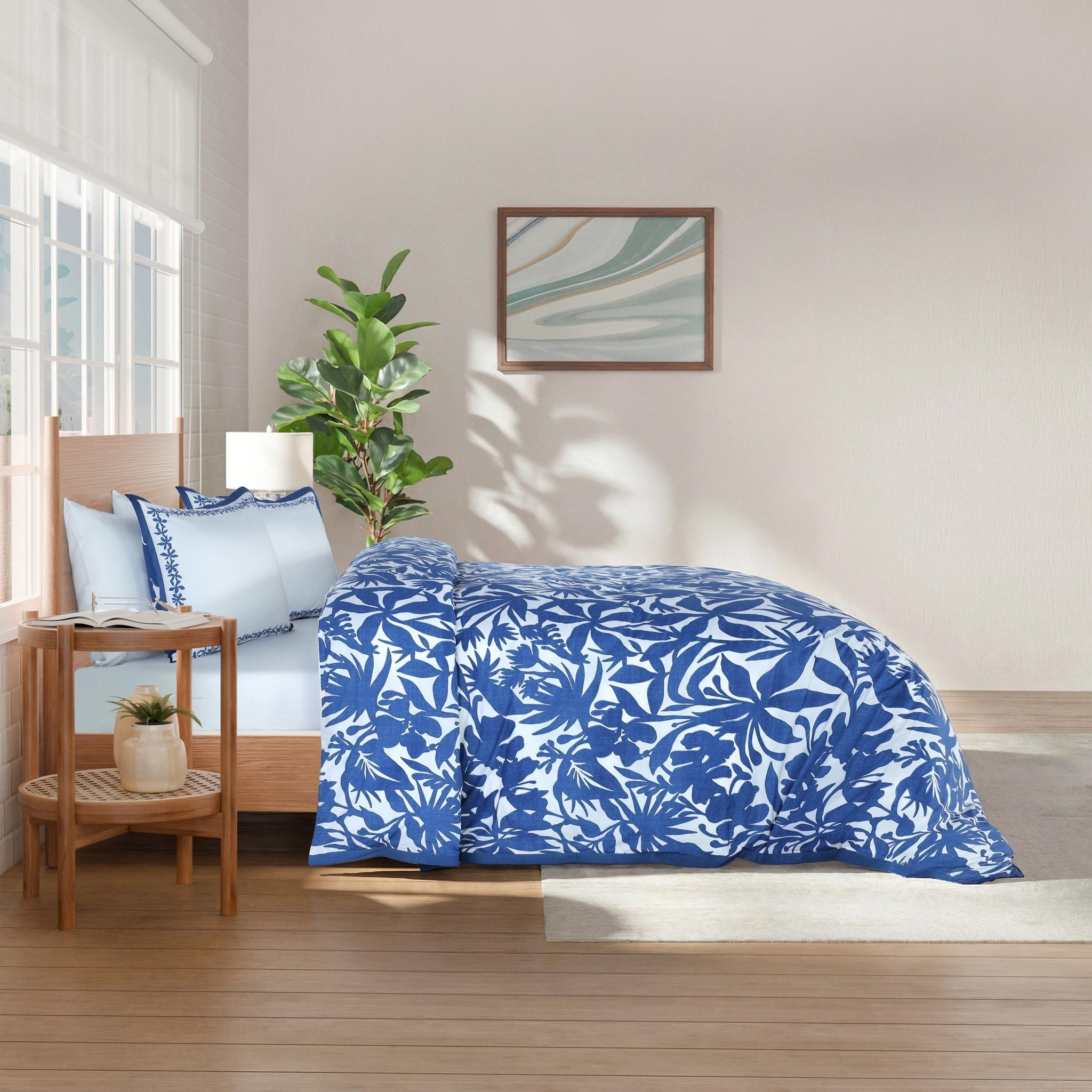Bedroom with blue floral comforter and pillow shams.