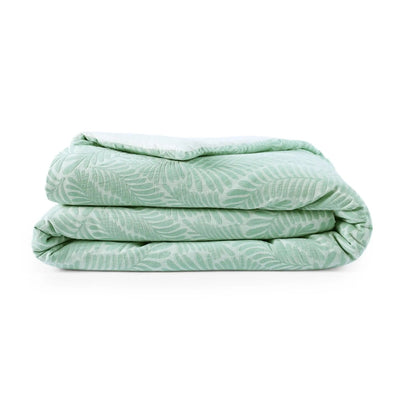 Folded light green comforter with a subtle pattern on a white background