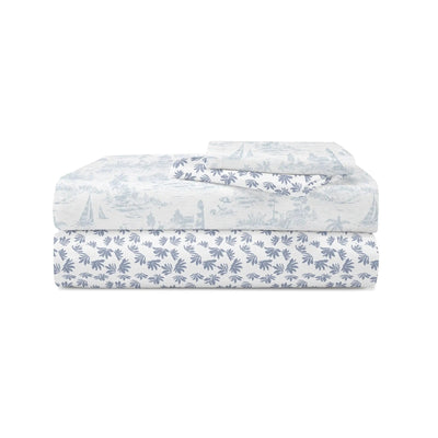 Folded bedding set with a light blue and white toile de Jouy print, featuring a scenic landscape pattern on the top sheet and a leafy pattern on the pillowcase, set against a plain white background.