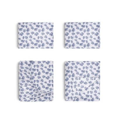 Four folded rectangular fabric pieces arranged in a 2x2 grid on a white background, each showing a repeating blue leaf or palm-like print on a white base.
