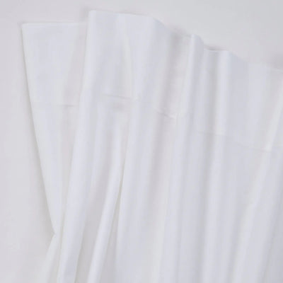 White fabric with a smooth texture, draped in soft folds against a light background.