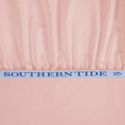A close-up of a light pink fabric product, likely a beach cover-up or dress, gathered at the waistband with a white elastic band featuring the blue 'SOUTHERN TIDE' brand name and logo.