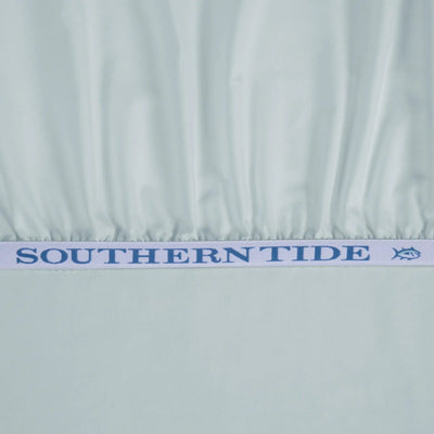 A close-up of a light blue fabric with a gathered elastic band featuring the blue text 'SOUTHERN TIDE' and a small fish logo.