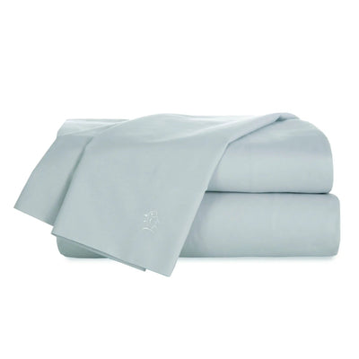 Light blue bed sheets stacked on a white background