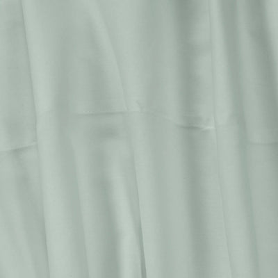 A close-up of draped light sage green fabric with soft folds and a subtle sheen.