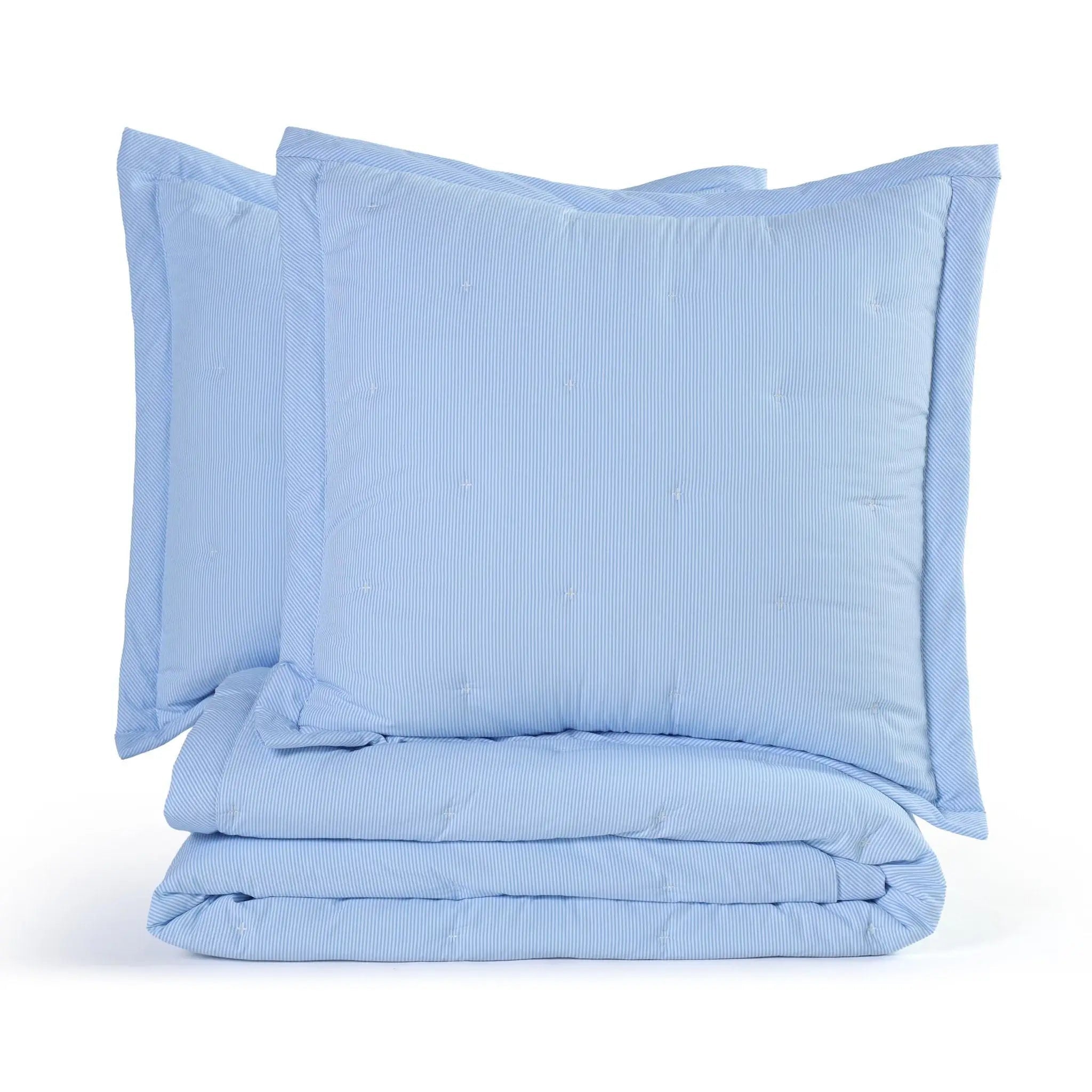 A light blue quilt set including a folded quilt and two matching euros, on a clean white background.