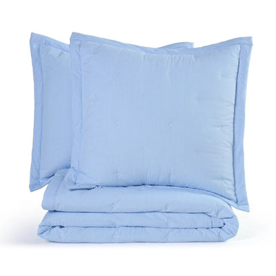 A light blue quilt set including a folded quilt and two matching euros, on a clean white background.