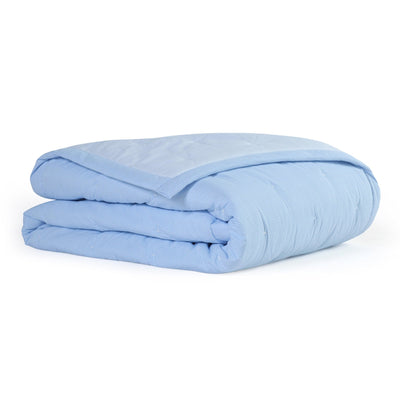 Folded light blue quilt on a white background