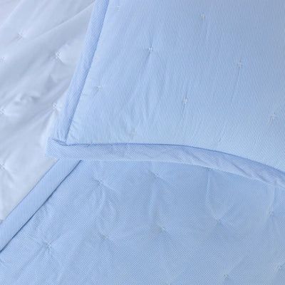 A close-up of a light blue quilt bedding set.