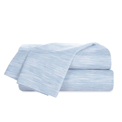 Stack of light blue striped bed sheets on a white background