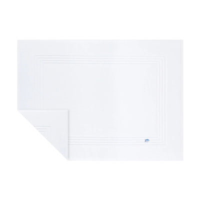 A white bath mat with a subtle concentric border design and a small blue logo in the bottom right corner, shown on a plain white background.