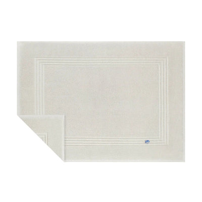 Grey textured bath mat with a brand logo on a white background