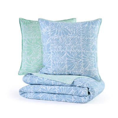 Folded blue and green patterned comforter with matching euro shams on a white background