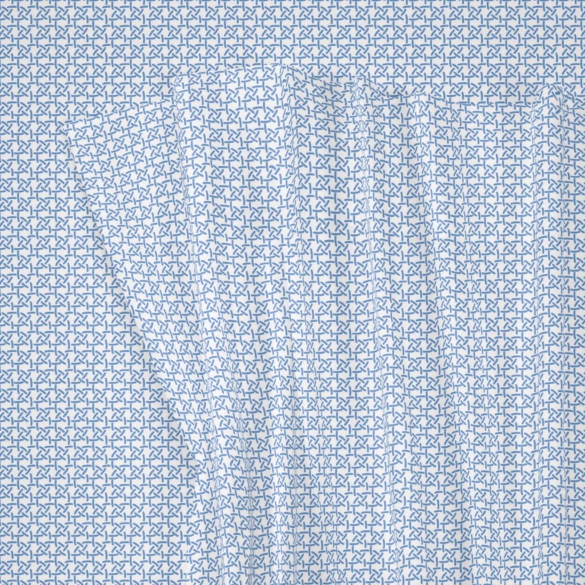 A close-up of a light blue and white fabric with a repeating geometric pattern of interlocking stylized letters or shapes.
