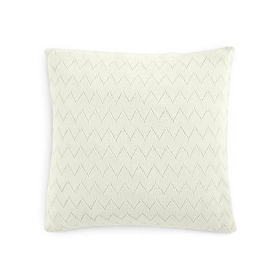 A square throw pillow in a warm off-white or cream color, featuring a subtle, tonal dotted chevron pattern across the front, set against a plain white background.