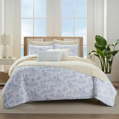 Bed with blue and white patterned comforter set in a bright bedroom