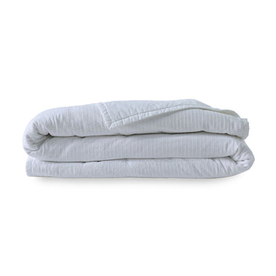 Folded white quilt on a white background
