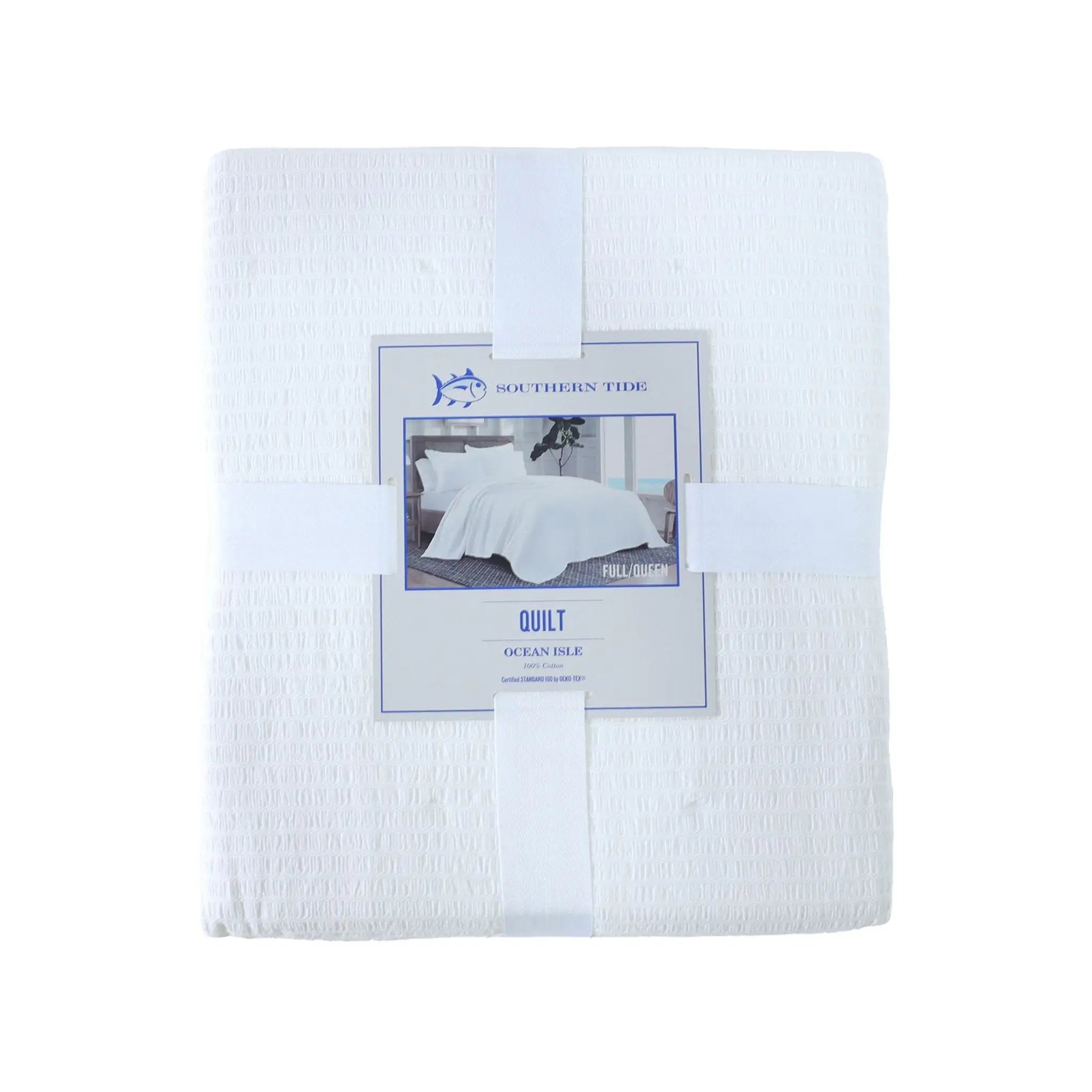 A folded white quilted cotton quilt wrapped in a white paper band with a central product label, shown against a plain white background.