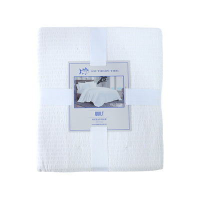 Front view of white quilt with packaging on a white background