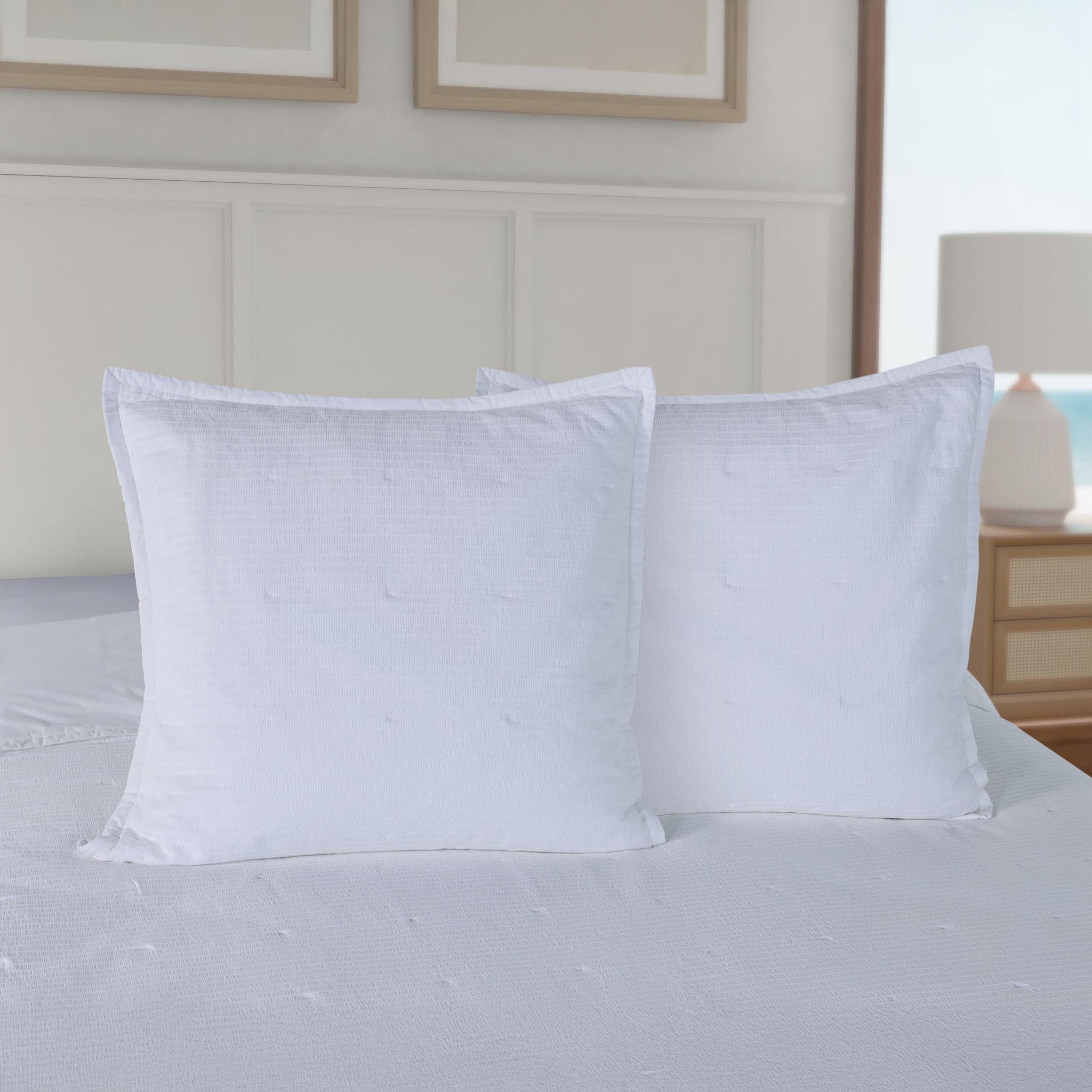 Two white shams on a bed in a bedroom setting.