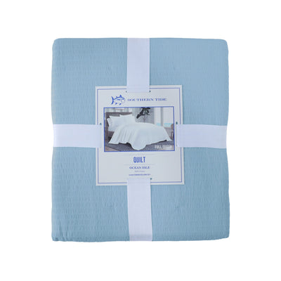 Blue quilt with front view packaging on a white background