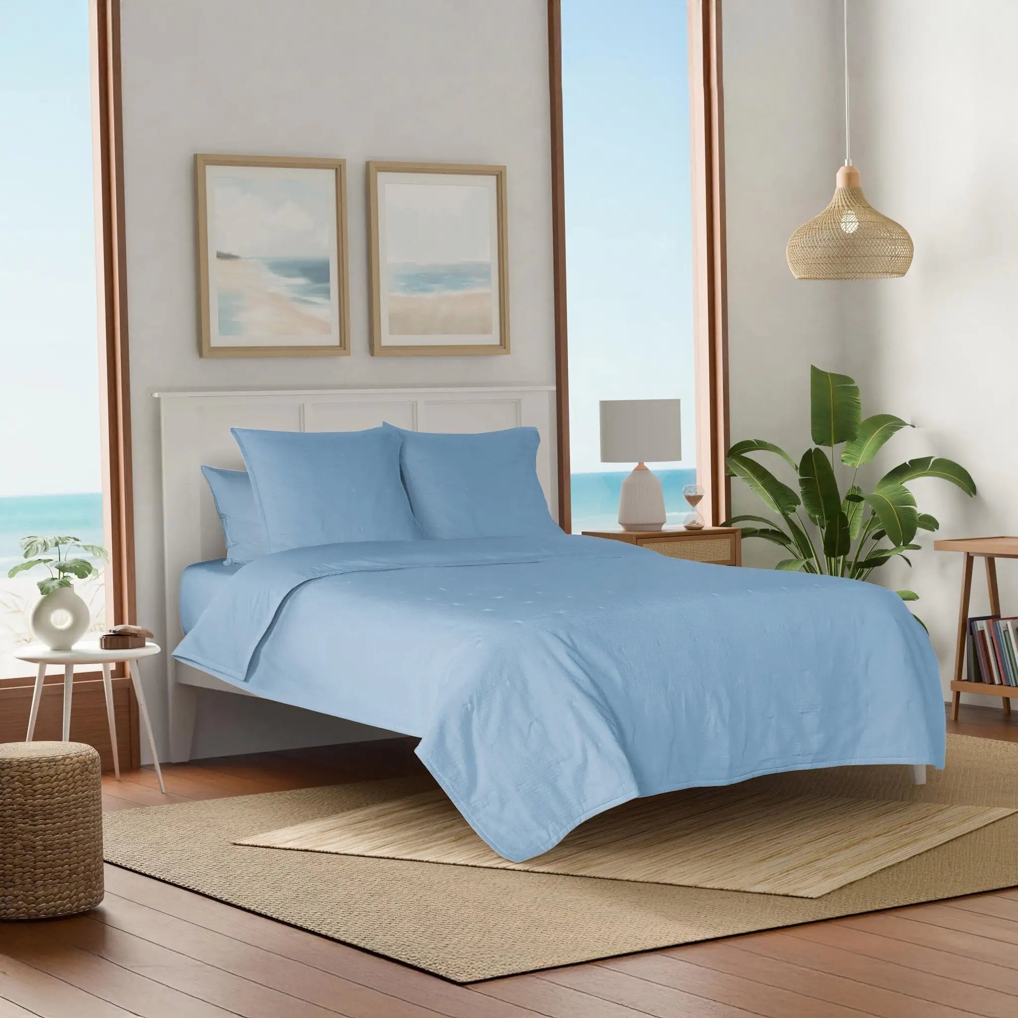 Bedroom with light blue quilt and euros.
