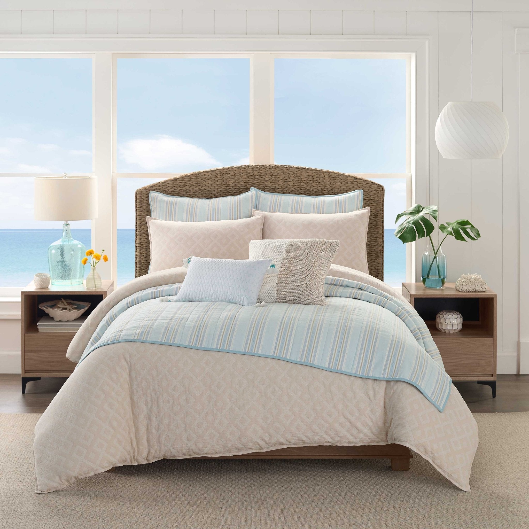 Bedroom with a bed featuring a beige and blue comforter and pillow shams.