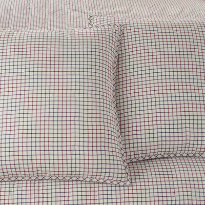Grid-patterned fabric with two euro shams on a matching background.