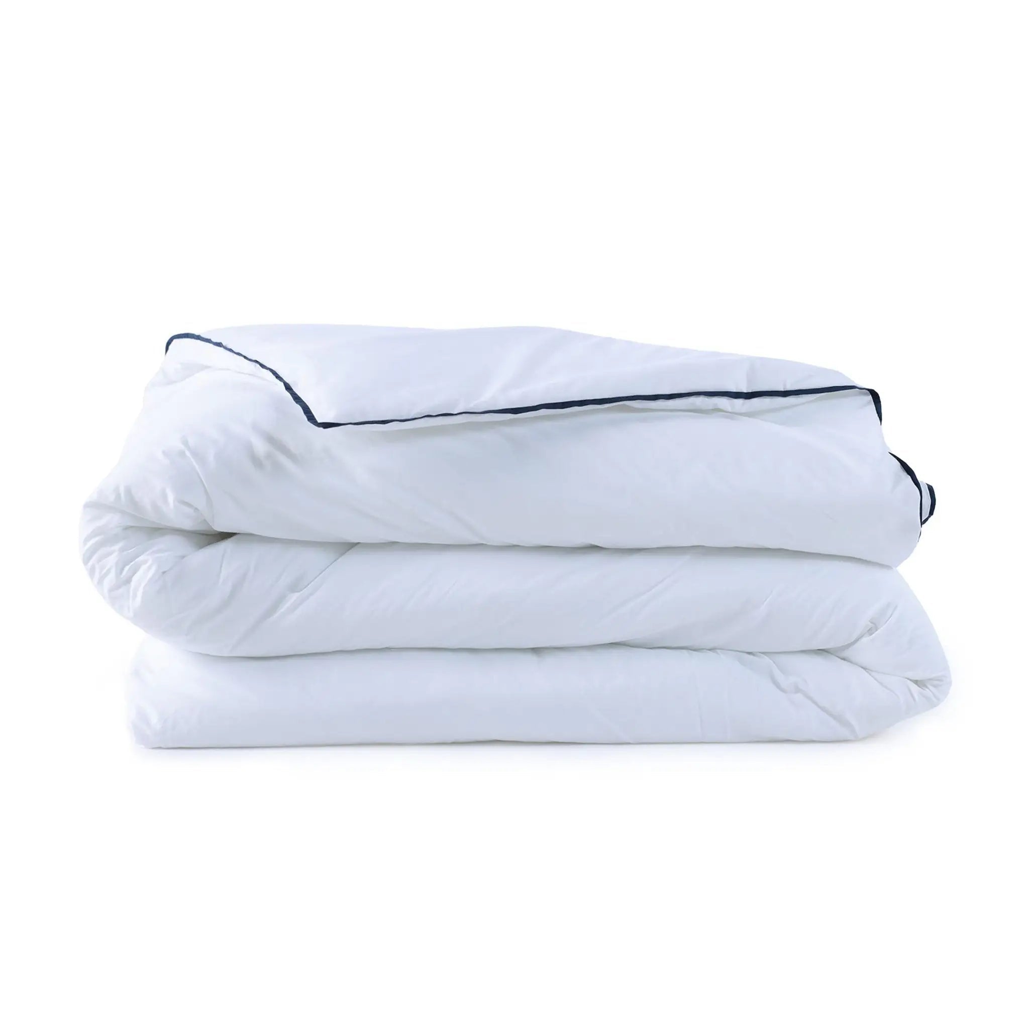 A folded white comforter with a thin dark blue piping trim, stacked neatly on a solid white background.