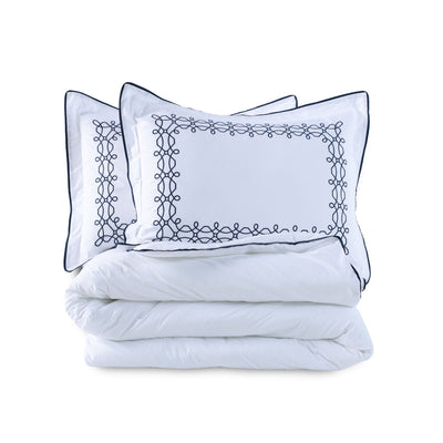 White comforter set with embroidered shams on a white background